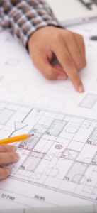 Architekt zeigt auf einen Bauplan